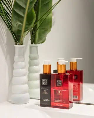a table with three bottles of soap and a vase at Janika's Apartment in Porto