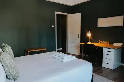a bedroom with a white bed with a desk and a desk at Five Seven Nine Apartments in Porto