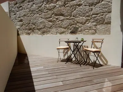 a table and chairs in a room with a brick wall at Oporto Downtown Apartment in Porto