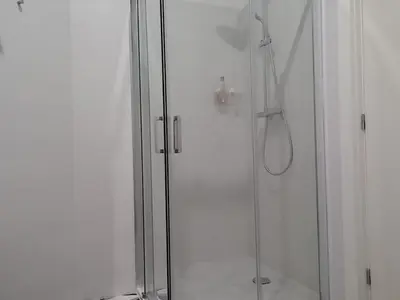 a shower with a glass door with a shower head at Oporto Downtown Apartment in Porto