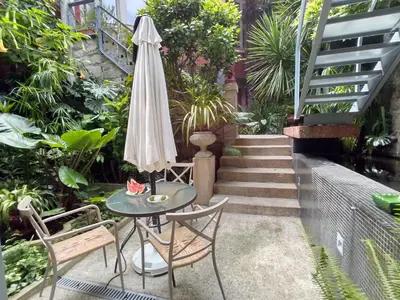 a patio with a table and an umbrella and stairs at Garden House in Porto