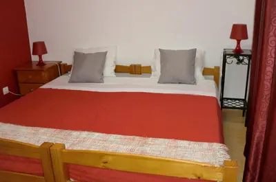 a bed with a red blanket and two pillows at The Yellow House in Vila Nova de Gaia