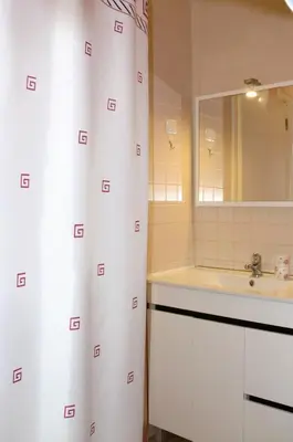 a bathroom with a white shower curtain and a sink at The Yellow House in Vila Nova de Gaia