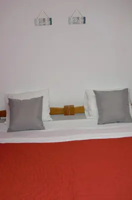 a bed with two pillows and a red blanket at The Yellow House in Vila Nova de Gaia