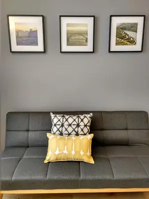 a gray couch in a living room with three pictures on the wall at PicPorto Apartment in Porto