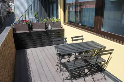 a table and chairs on a balcony with a table and benches at LL Picaria 16 in Porto