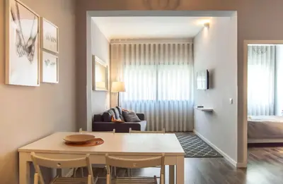a dining room and living room with a table and chairs at LL Picaria 16 in Porto