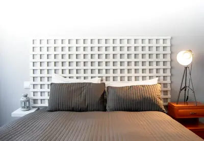 a bed with a large white headboard in a bedroom at LL Picaria 16 in Porto