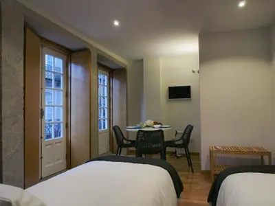 a room with two beds and a table with chairs at Belomont6 Apartments in Porto