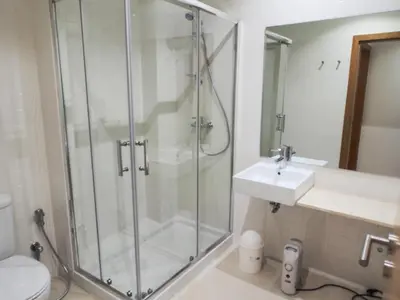 a bathroom with a glass shower and a sink at Belomont6 Apartments in Porto