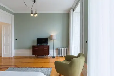 a living room with a chair and a television at GuestReady - Picaria Living Quarters in Porto