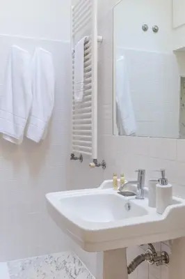 a white bathroom with a sink and a mirror at GuestReady - Picaria Living Quarters in Porto