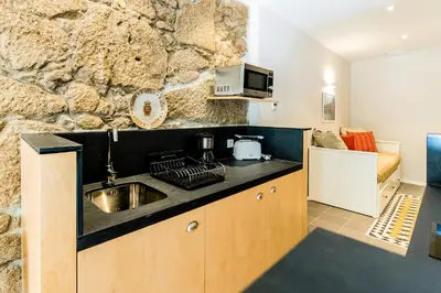 a kitchen with a sink and a stone wall at Oporto Trendy River in Porto