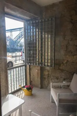a room with a balcony with a chair and a table at Oporto Trendy River in Porto