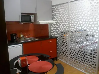 a kitchen with a red chair and a sink at Metro-Apartment RNAL nº35375 AL-Chamada para a rede móvel nacional in Porto