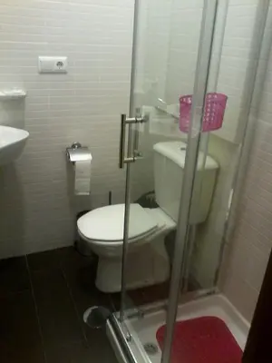 a bathroom with a toilet and a glass shower at Metro-Apartment RNAL nº35375 AL-Chamada para a rede móvel nacional in Porto