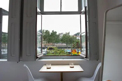 a table with two glasses in front of a window at Goabio Studio River View in Porto