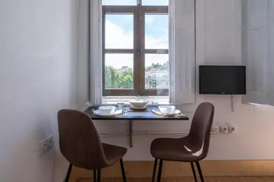 a table with two chairs in front of a window at Goabio Studio River View in Porto