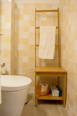 a bathroom with a toilet and a towel on a shelf at Goabio Studio River View in Porto