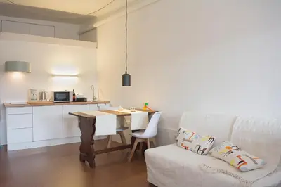 a living room with a table and a white couch at Goabio Studio River View in Porto