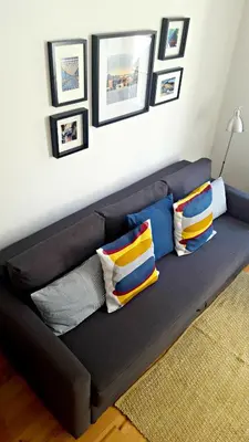 a black couch with colorful pillows in a living room at Flowers Center in Porto