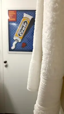 a stack of white towels in front of a door at Flowers Center in Porto