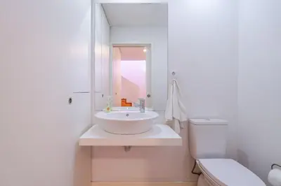 a white bathroom with a sink and a toilet at Apartamento City Center in Porto