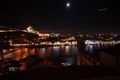 a view of a river at night with a bridge at Porto Riverside in Porto