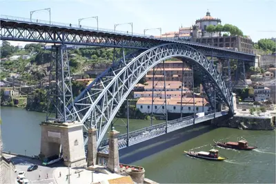 a bridge over a river with boats in the water at Porto Riverside in Porto