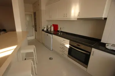 a kitchen with white cabinets and a counter top at Porto Riverside in Porto