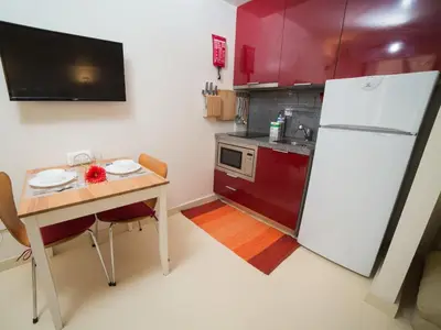a kitchen with a table and a white refrigerator at OPORTO GUEST - Cedofeita in Porto