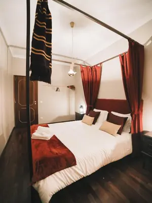 a bedroom with a canopy bed with red curtains at OPORTO GUEST Harry Potter flat with Parking in Porto