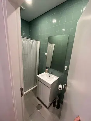 a green bathroom with a sink and a shower at Down Bonjardim Apartments in Porto