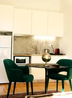 a kitchen with a table and two green chairs at Oporto Chic&Cozy - Batalha in Porto