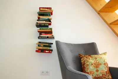 a chair with a pillow next to a stack of books at Oporto Chic&Cozy - Batalha in Porto