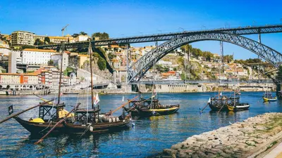 a group of boats in the water under a bridge at Gardenia Urban Retreat in Porto