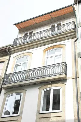 a white building with a balcony on top of it at Andorinha Apartment in Porto