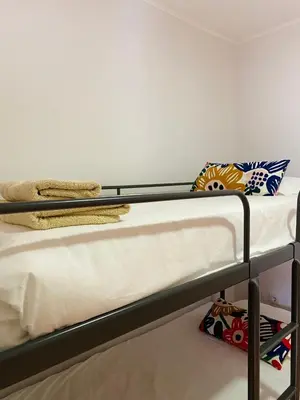 a bunk bed with white sheets and pillows on it at Casa Devesas in Vila Nova de Gaia