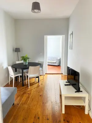 a living room with a table and a tv in it at Casa Devesas in Vila Nova de Gaia