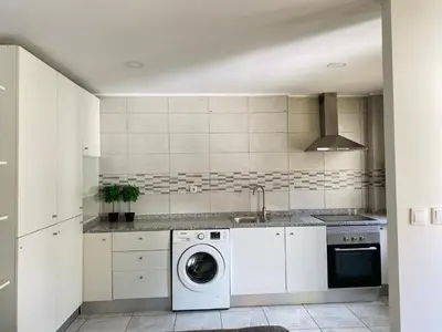 a kitchen with a washing machine and a sink at Casa Devesas in Vila Nova de Gaia