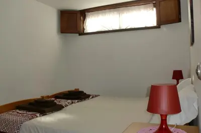 a bedroom with a bed with a red lamp and a window at The Yellow House 3 in Porto