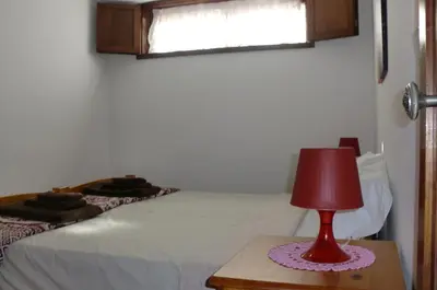 a bedroom with a bed and a red lamp on a table at The Yellow House 3 in Porto