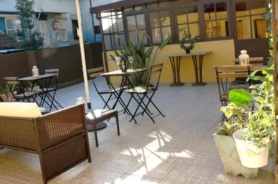 an outdoor patio with tables and chairs and plants at The Yellow House 3 in Porto