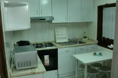 a kitchen with white cabinets and a stove and a sink at The Yellow House 3 in Porto