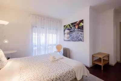 a white bedroom with a bed and a window at Music House 3 bedroom Apt w garage in Porto