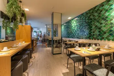a restaurant with wooden tables and green walls at Hotel Spot Family Suites in Porto