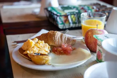 a plate of breakfast food and an apple and orange juice at Hotel Spot Family Suites in Porto