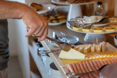 a person is reaching for a tray of cheese at Hotel Spot Family Suites in Porto