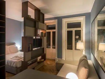 a room with a bed and a couch and a tv at Domum 2 in Porto