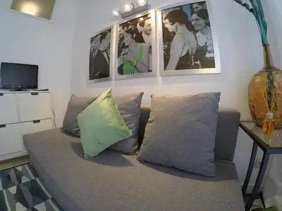a living room with a couch and pictures on the wall at Apartamento Da Lapa in Porto